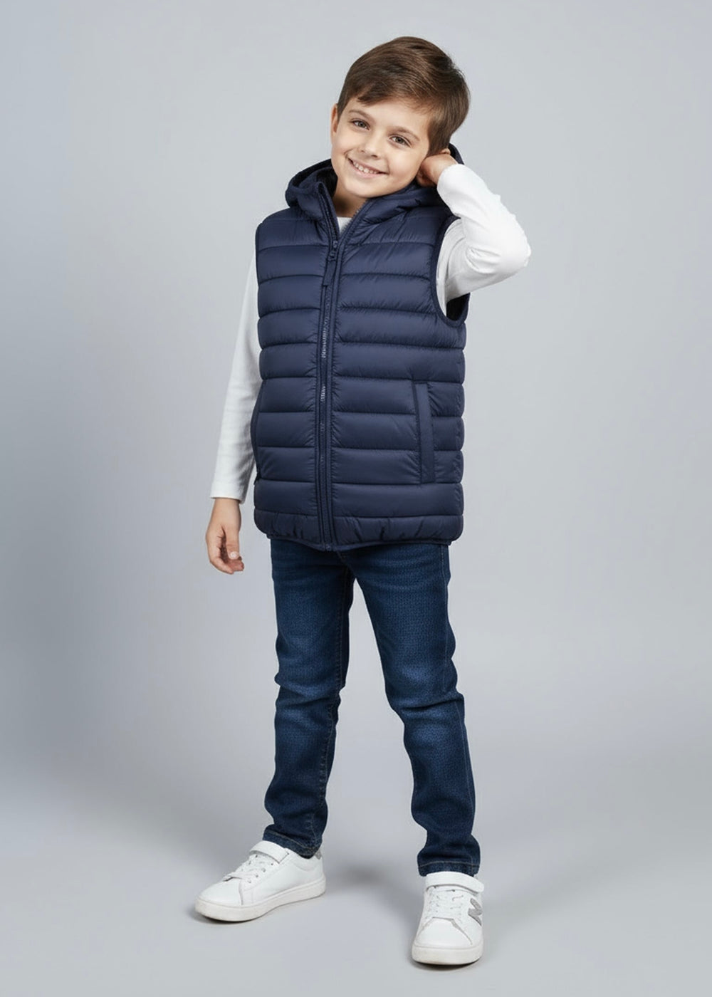 Child wearing a navy puffer vest on a gray background