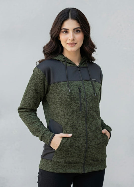 Woman wearing a green and black textured hoodie against a plain background