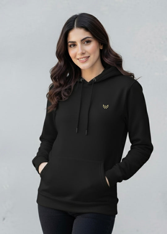Woman wearing a black hoodie with a small logo on a gray background