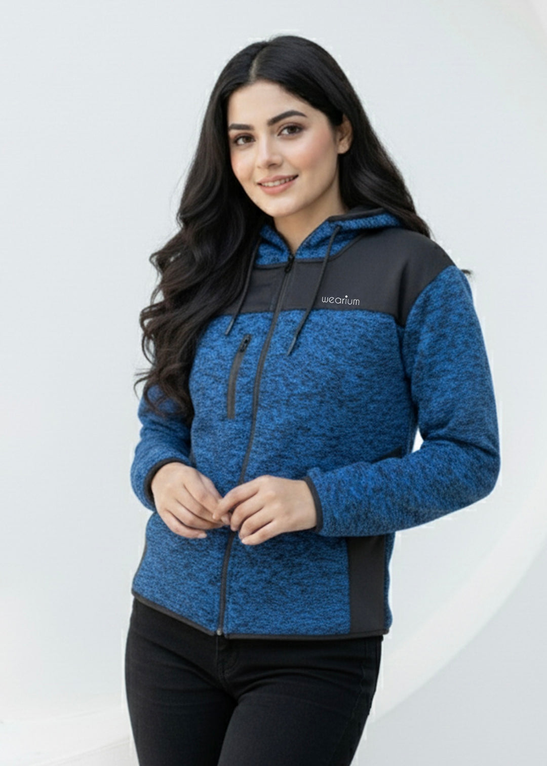 Woman wearing a blue and black hoodie with a visible brand logo on a white background