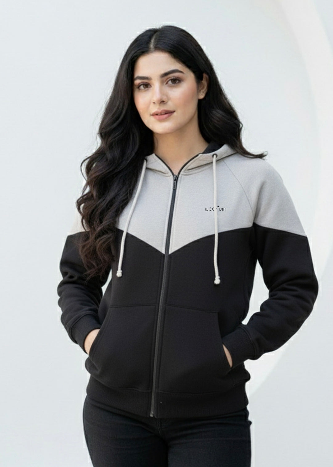 Woman wearing a black and gray hoodie with a white background