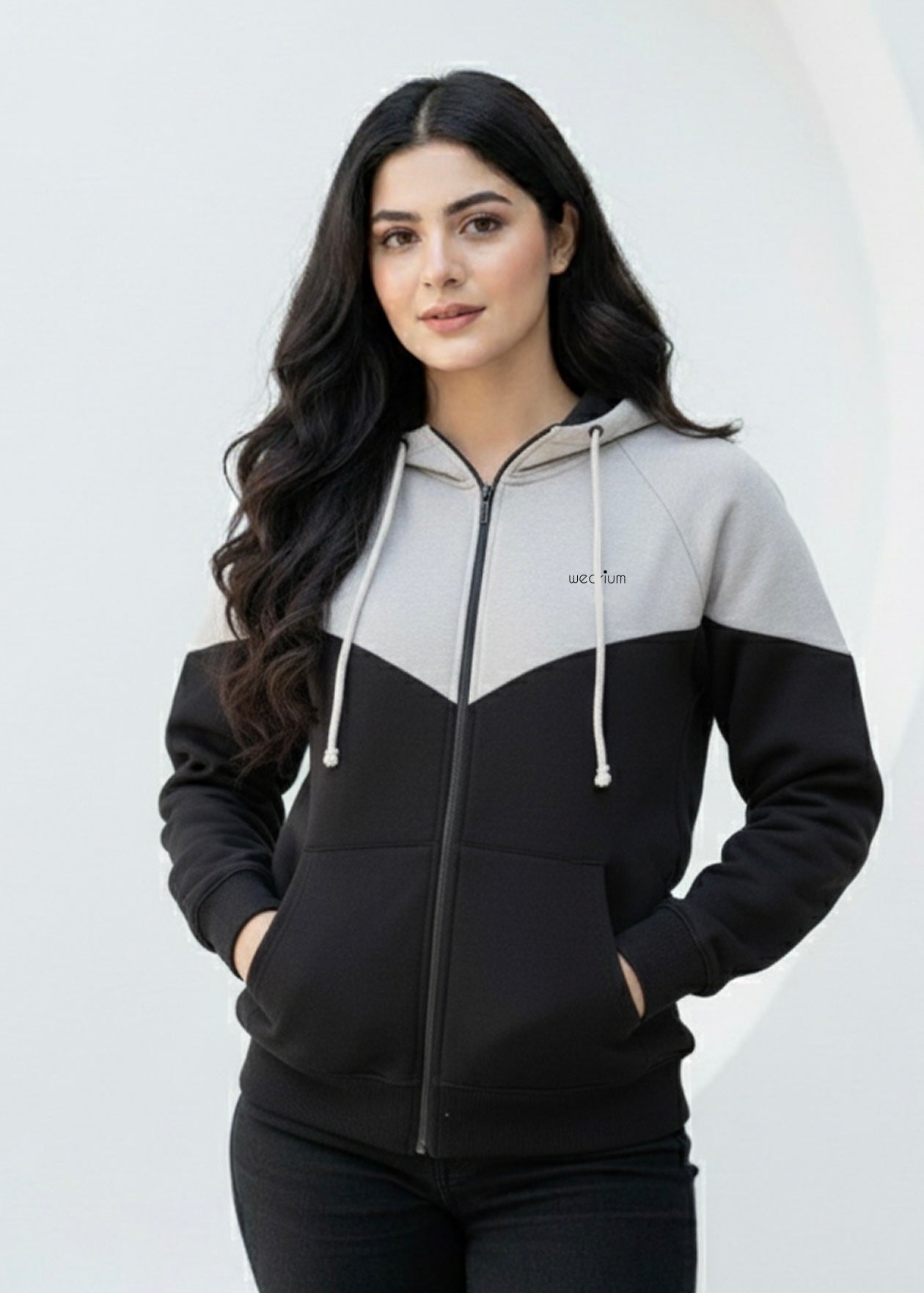 Woman wearing a black and gray hoodie with a white background