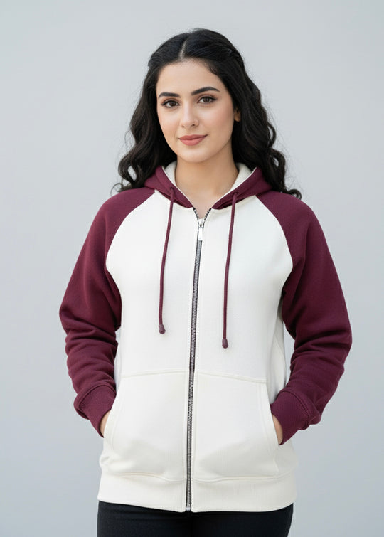 Woman wearing a white and burgundy hoodie on a gray background