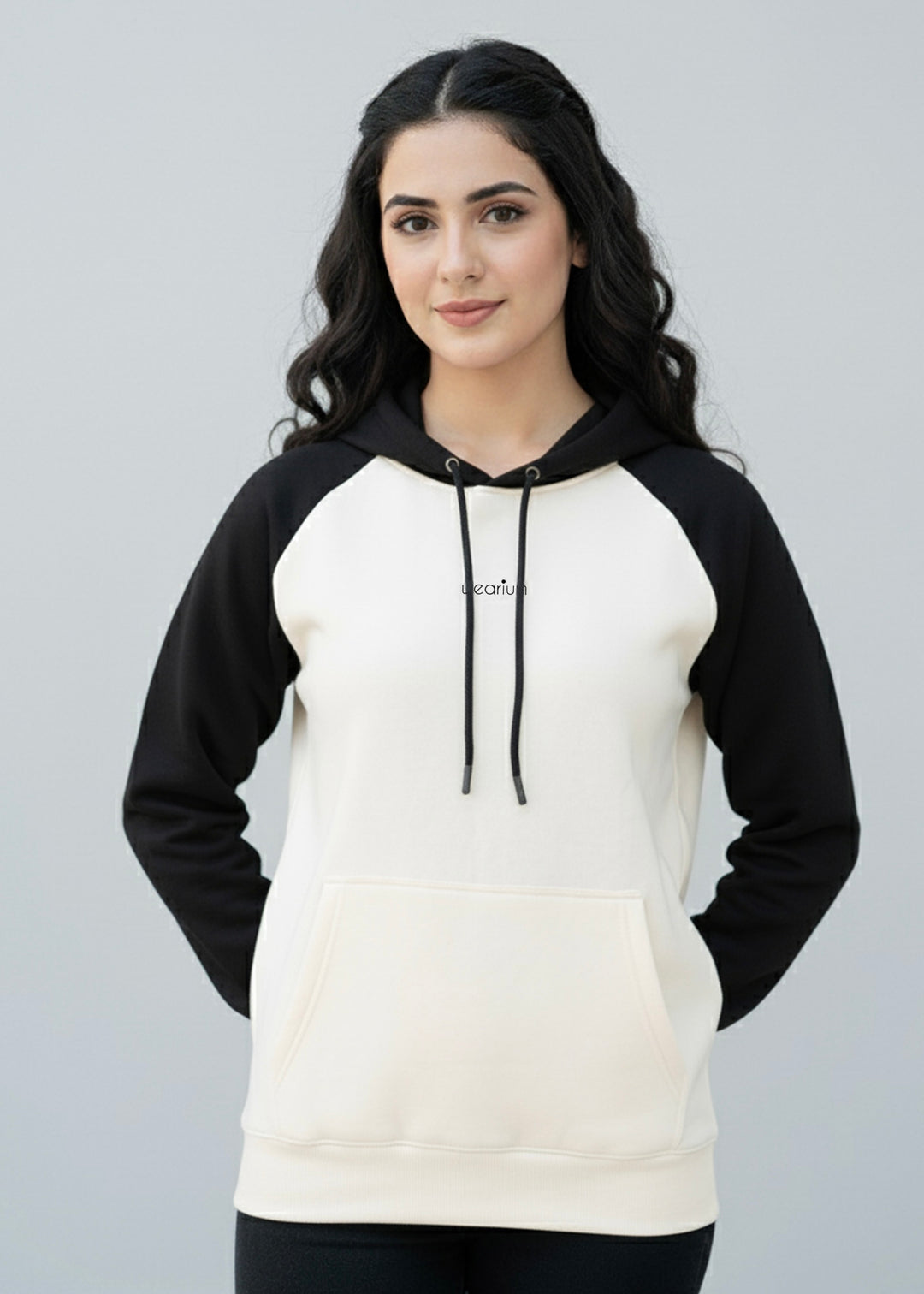 Woman wearing a black and white hoodie with a plain background
