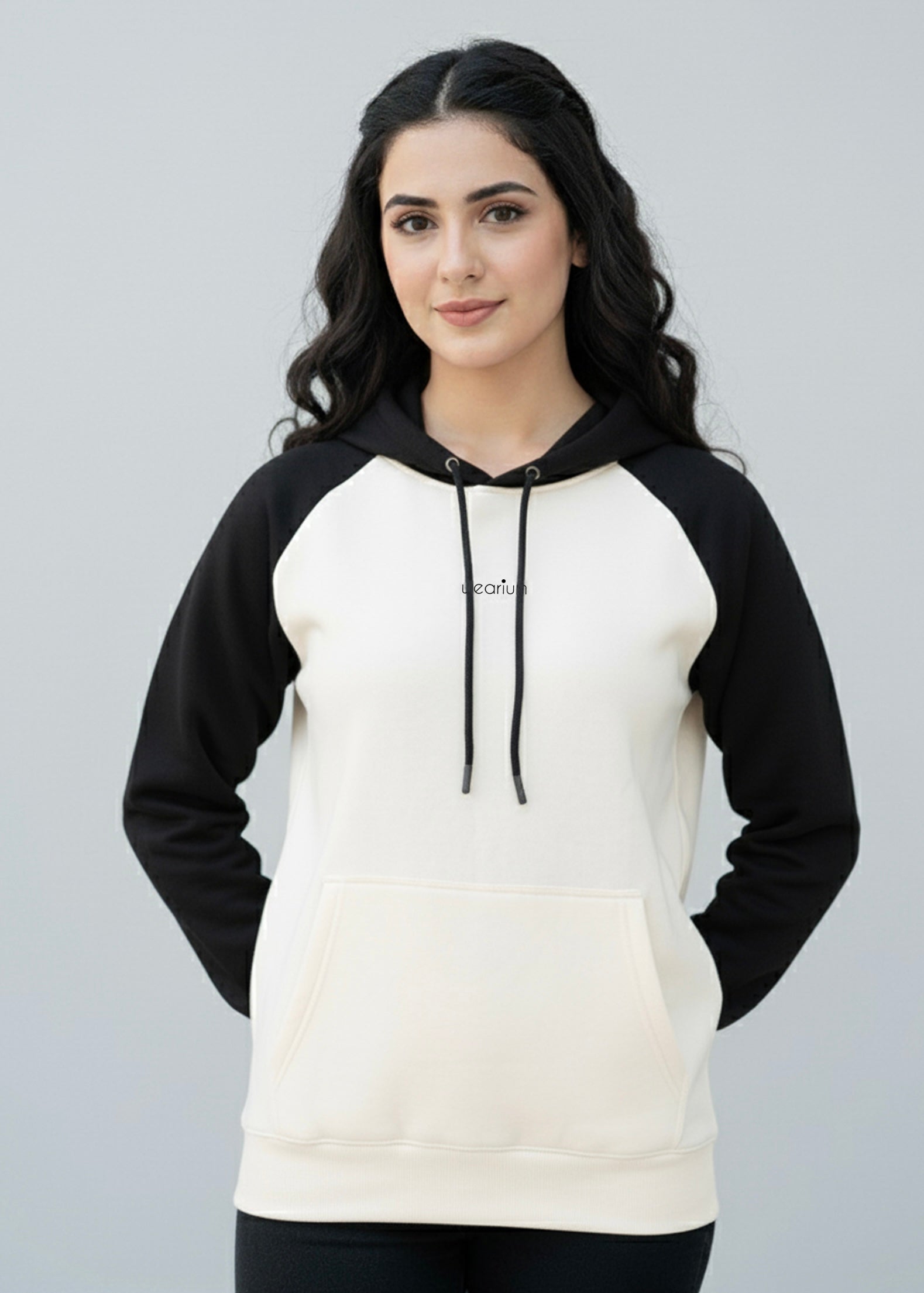 Woman wearing a black and white hoodie with a plain background