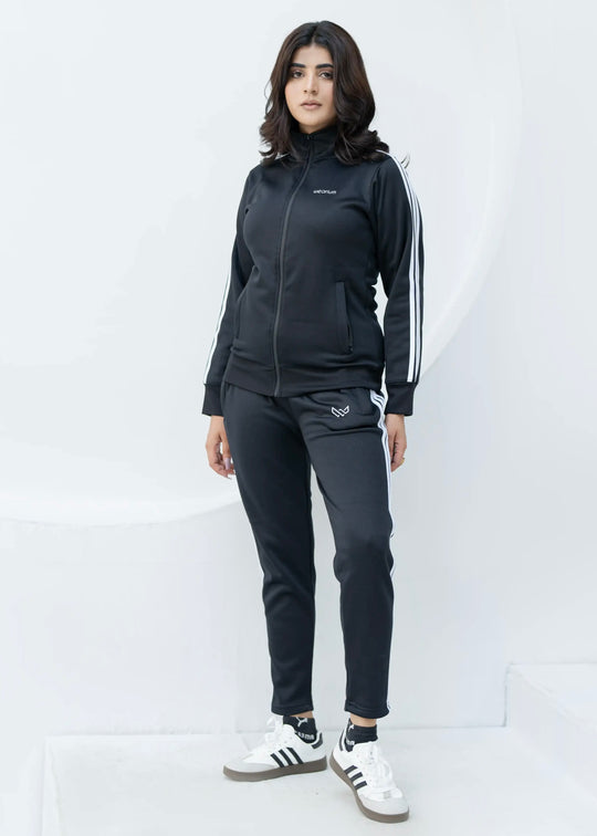 Woman wearing a black tracksuit with white stripes on a white background
