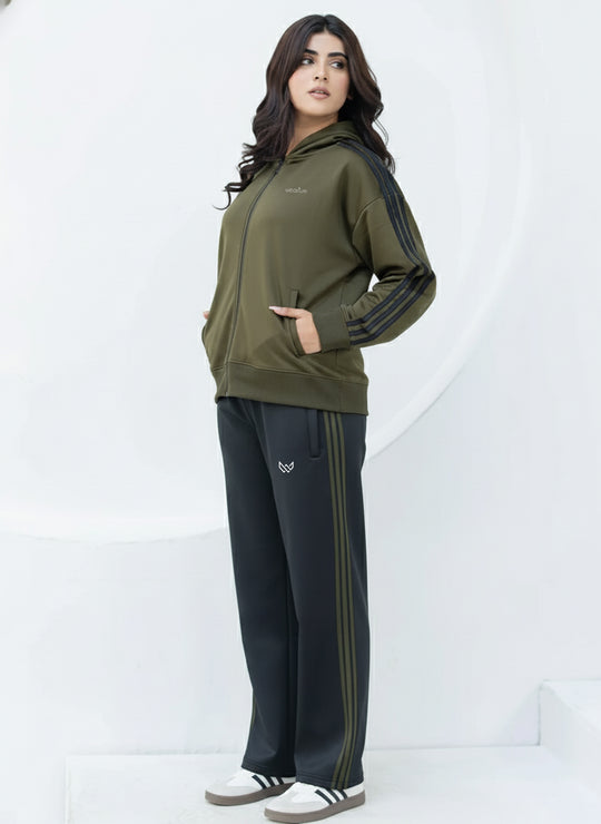 Woman wearing a green tracksuit with black pants on a white background