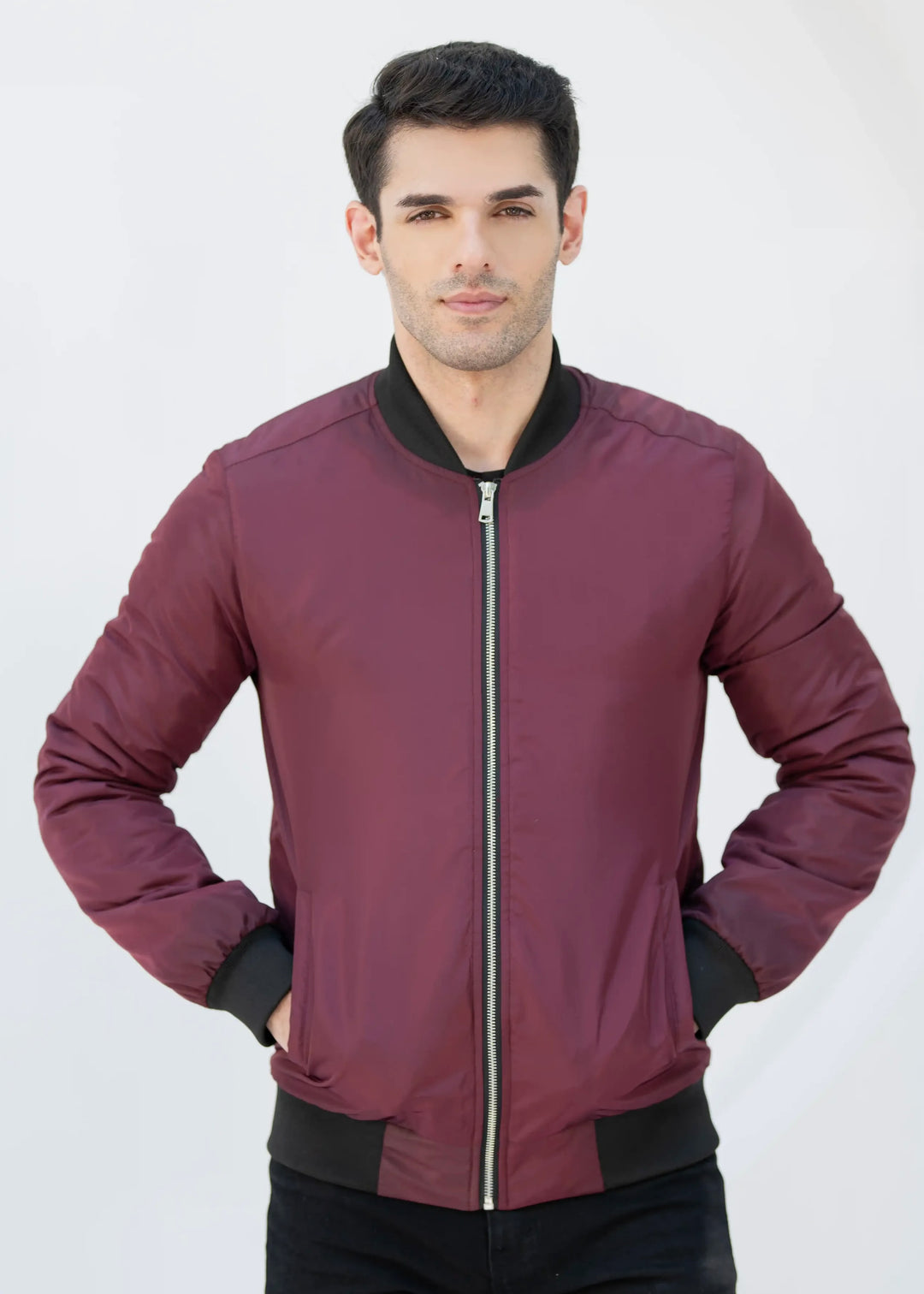 Man wearing a maroon jacket with black accents on a white background