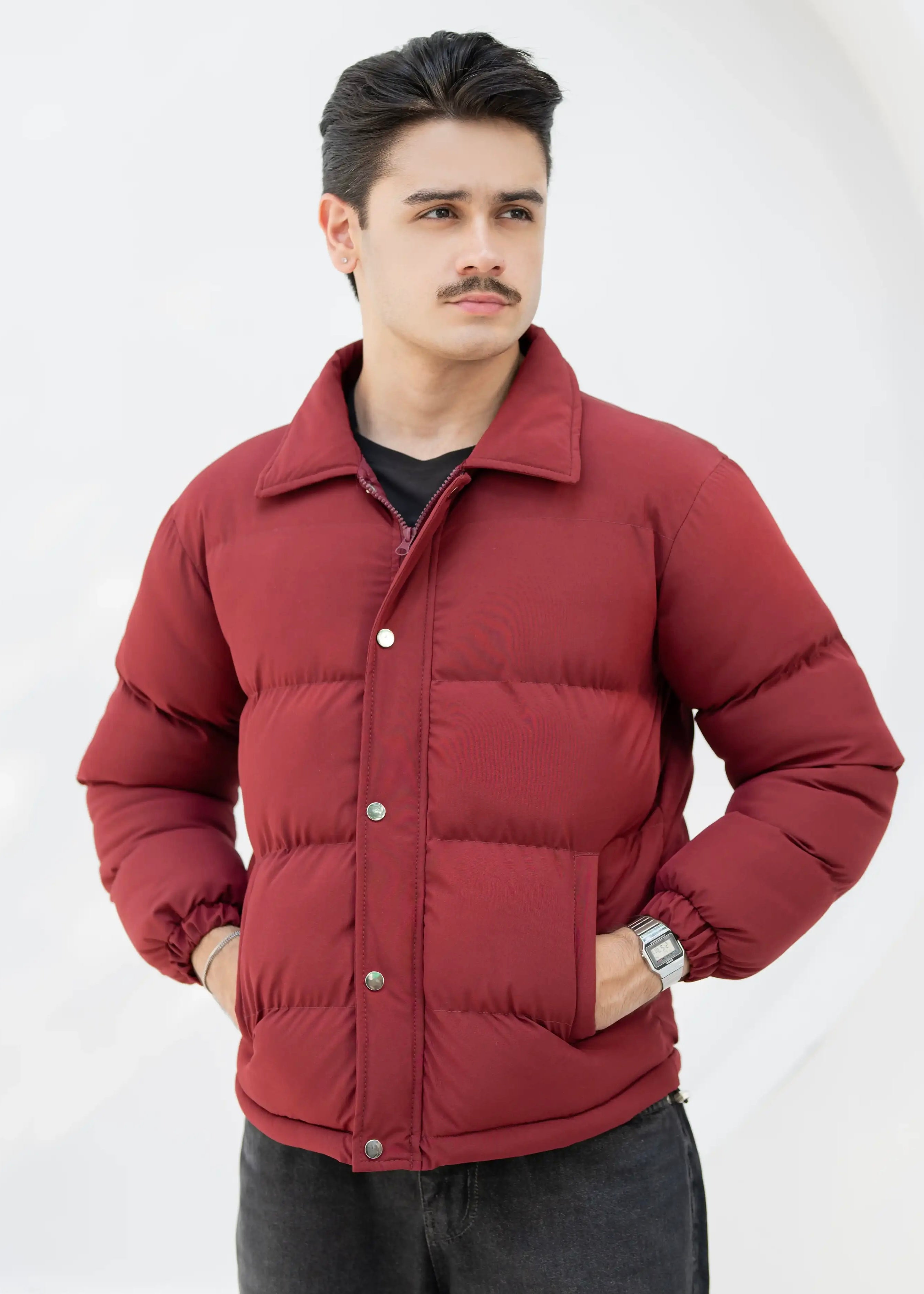 Man wearing a red puffer jacket against a white background